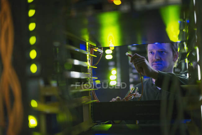 Técnico de sala de servidor com cabo no painel — Fotografia de Stock