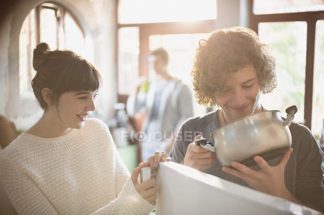 Young couple looking into pot at refrigerator — Stock Photo
