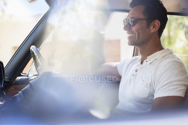Hombre conduciendo coche en día soleado - foto de stock