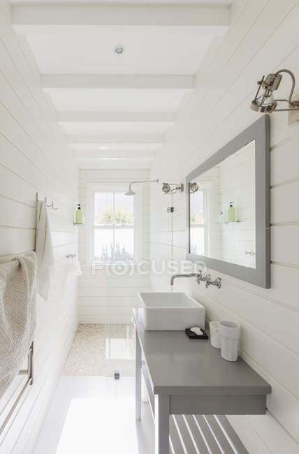 Длинная, солнечно-белая современная роскошная ванная комната — стоковое фото