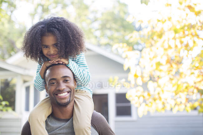 Retrato de feliz padre con hija en hombros - foto de stock