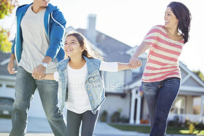 Happy family holding hands and running — Stock Photo