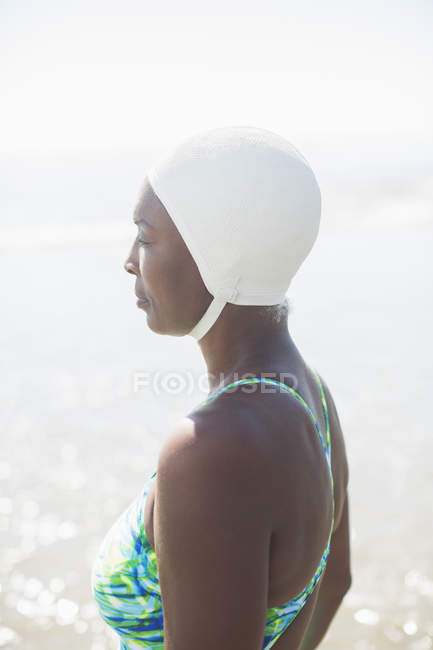 Вид збоку на стомлену жінку в купальнику і кепці — стокове фото