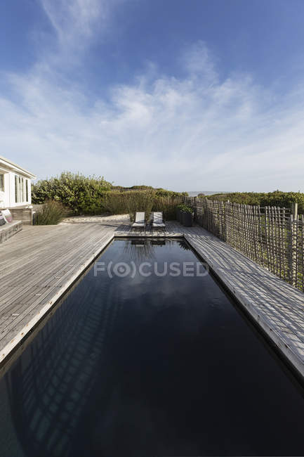 Dunkler Luxus-Pool unter sonnigem blauem Himmel — Stockfoto