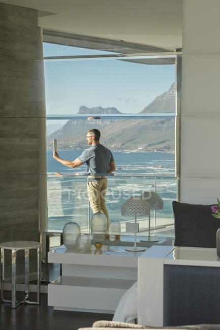 Spiegelung des Menschen mit digitaler Tablet-Kamera auf Luxus-Balkon mit Meerblick — Stockfoto