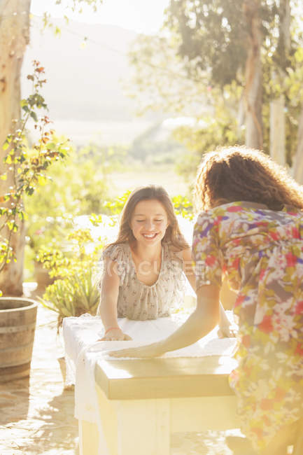 Мати і дочка кладуть на стіл тканину — стокове фото