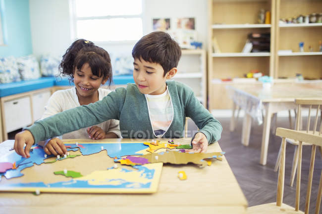 Students doing puzzle in classroom — Stock Photo