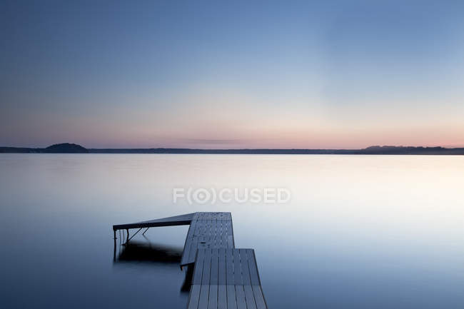 Dock over still lake, Saratoga Lake, Nueva York, Estados Unidos - foto de stock