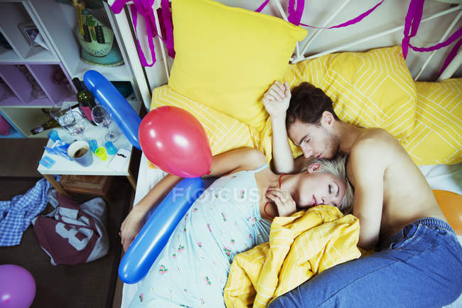 Пара спящих в постели после вечеринки дома — стоковое фото