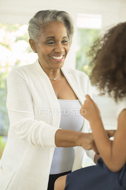 Grand-mère souriant à sa petite-fille — Photo de stock