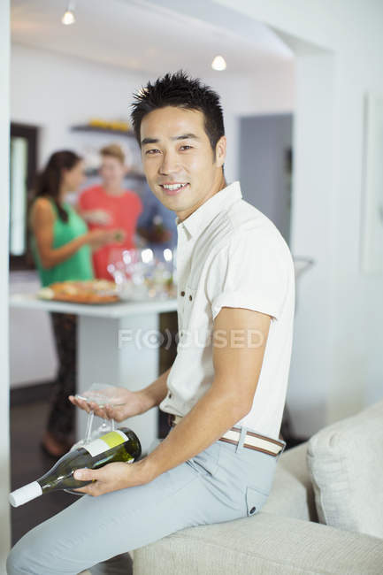 Man holding bottle of wine at party — Stock Photo