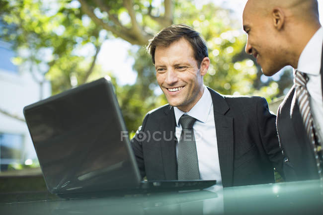 Uomini d'affari che utilizzano laptop all'aperto — Foto stock
