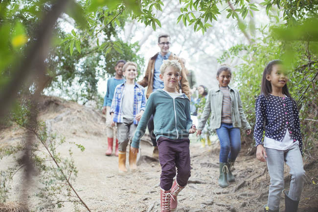 Students and teacher walking in forest — Stock Photo