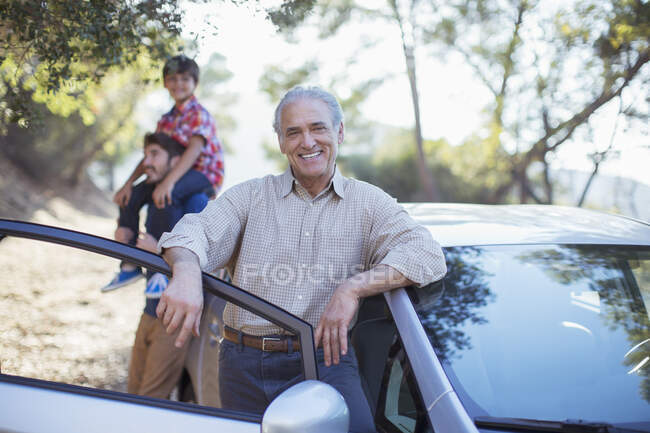 Portrait of senior man leaning on car — Stock Photo
