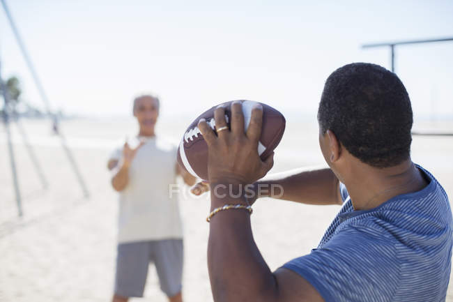 Hombres mayores jugando al fútbol en la playa - foto de stock