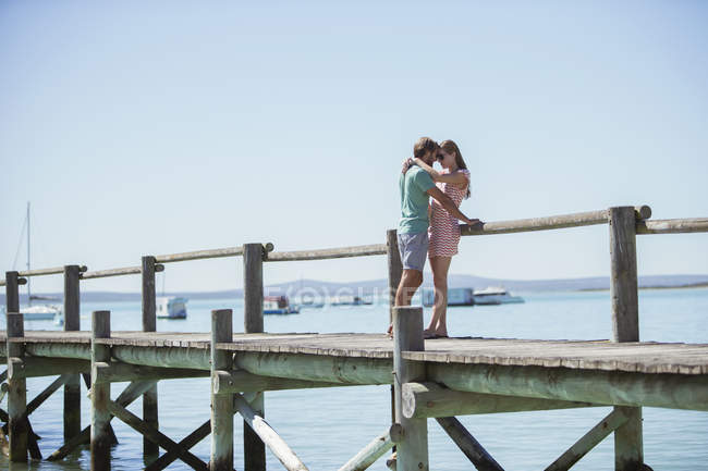 Couple hugging on wooden dock — Stock Photo