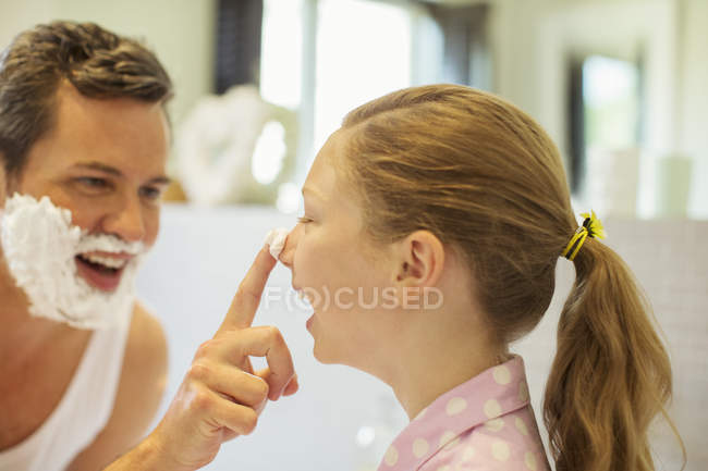 Father and daughter playing with shaving cream in bathroom — Stock Photo