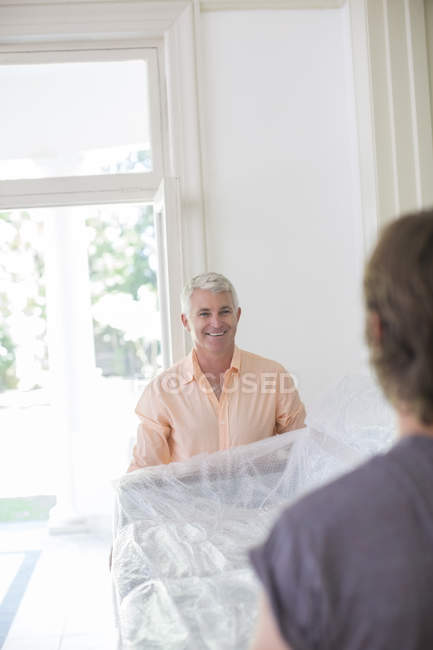 Father and son carrying couch — Stock Photo