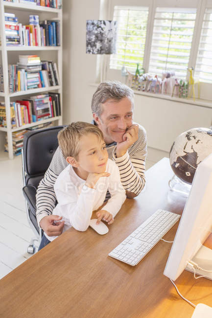 Vater und Sohn nutzen gemeinsam Computer — Stockfoto