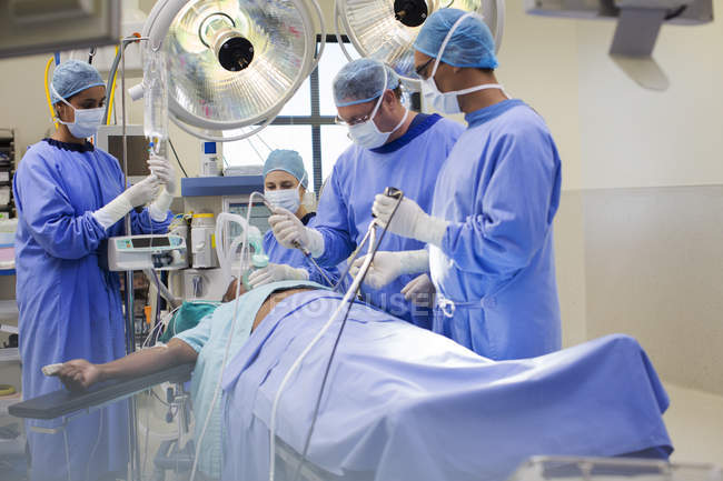 Équipe de médecins effectuant une chirurgie laparoscopique en salle d'opération — Photo de stock