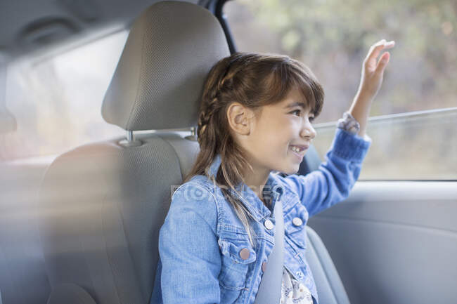 Menina feliz furando mão para fora janela do carro — Fotografia de Stock
