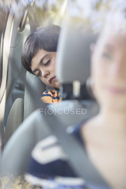 Garçon dormant sur le siège arrière de la voiture — Photo de stock