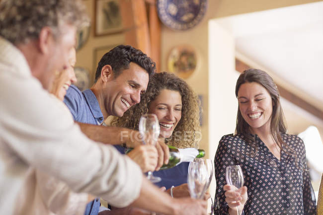 Homem derramando bebidas para os membros da família — Fotografia de Stock
