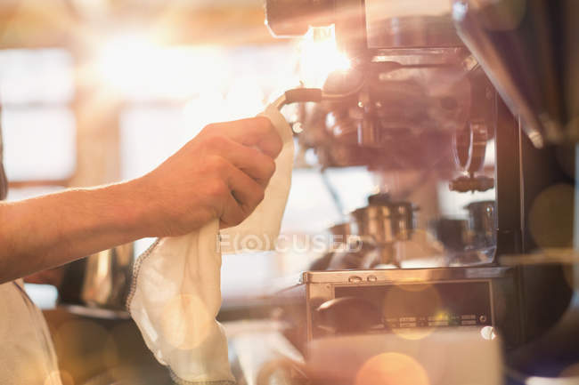 Close up barista wiping down espresso machine milk frother with rag in cafe — Stock Photo