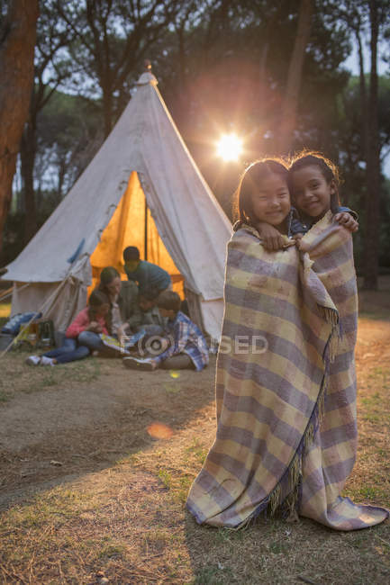 Children wrapped in blanket at campsite — Stock Photo