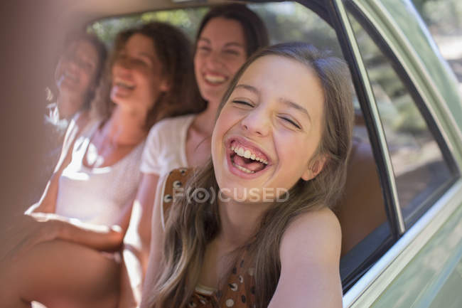 Cuatro mujeres jugando en el asiento trasero del coche - foto de stock
