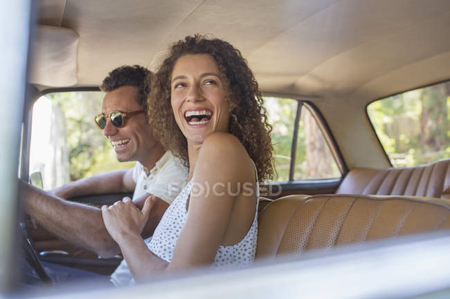 Heureux beau couple rire pendant la promenade en voiture — Photo de stock