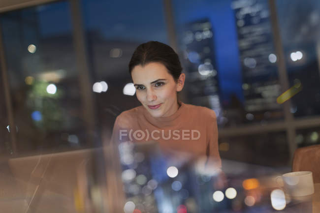 Businesswoman working late at laptop in office at night — Stock Photo