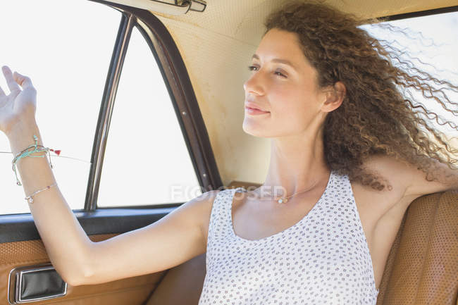 Жінка відчуває вітер з заднього сидіння автомобіля вікна — стокове фото
