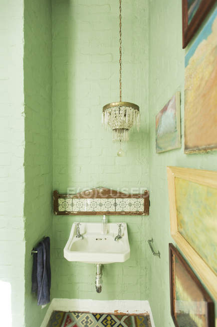 Раковина и люстра в деревенской ванной комнате — стоковое фото
