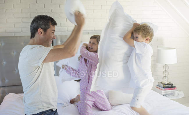 Отец и дети дерутся на подушках — стоковое фото