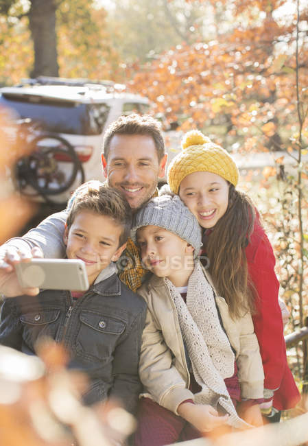 Família que toma selfie entre folhas de outono — Fotografia de Stock