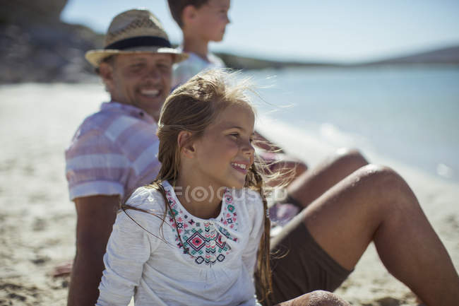 Jovem sentada com a família na costa — Fotografia de Stock