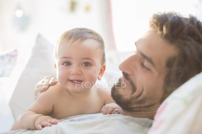 Padre y bebé niño relajándose en el sofá - foto de stock
