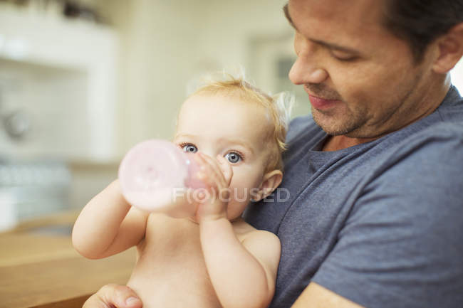 Pai alimentando bebê na cozinha — Fotografia de Stock