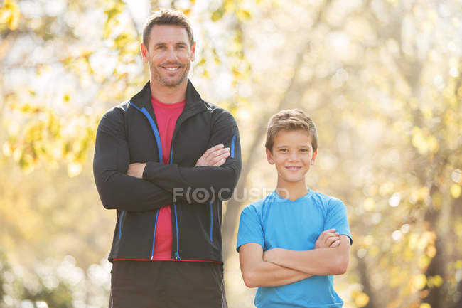 Portrait confident father and son with arms crossed outdoors — Stock Photo
