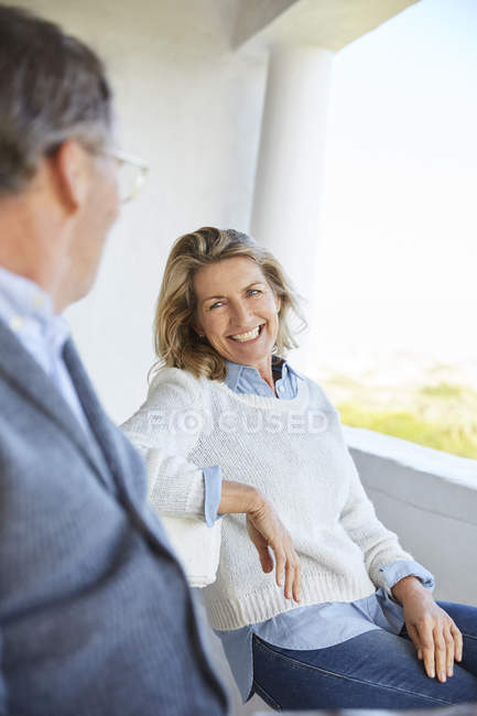 Sorridente coppia di anziani parlando sul patio — Foto stock