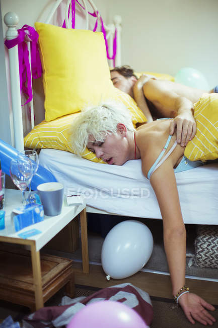 Jovem casal dormindo na cama de manhã após a festa dura — Fotografia de Stock