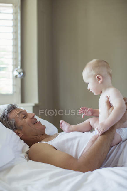 Pai e bebê relaxando na cama — Fotografia de Stock