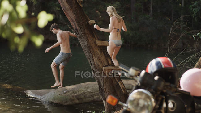 Молода пара на колоді на березі озера — стокове фото