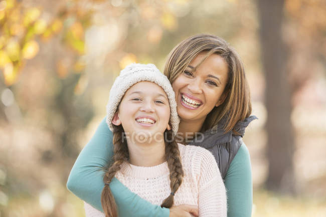 Retrato entusiasta madre e hija abrazándose al aire libre - foto de stock