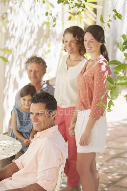 Heureuse famille moderne réunie autour de la table à l'extérieur — Photo de stock
