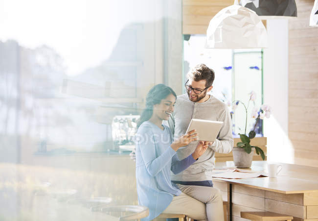 Casal usando tablet digital na cozinha — Fotografia de Stock