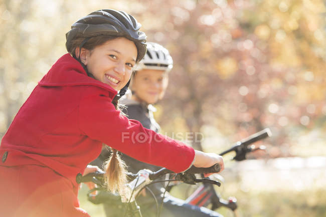 Portrait enthousiaste fille vélo équitation avec garçon — Photo de stock