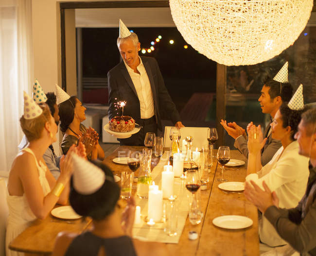 Mann serviert Geburtstagstorte auf Party — Stockfoto