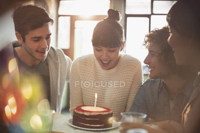 Молоді дорослі друзі святкують день народження з тортом і свічкою — стокове фото